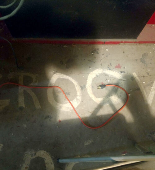 "Groovy" painted on the floor of a midcentury home’s utility/rec room.